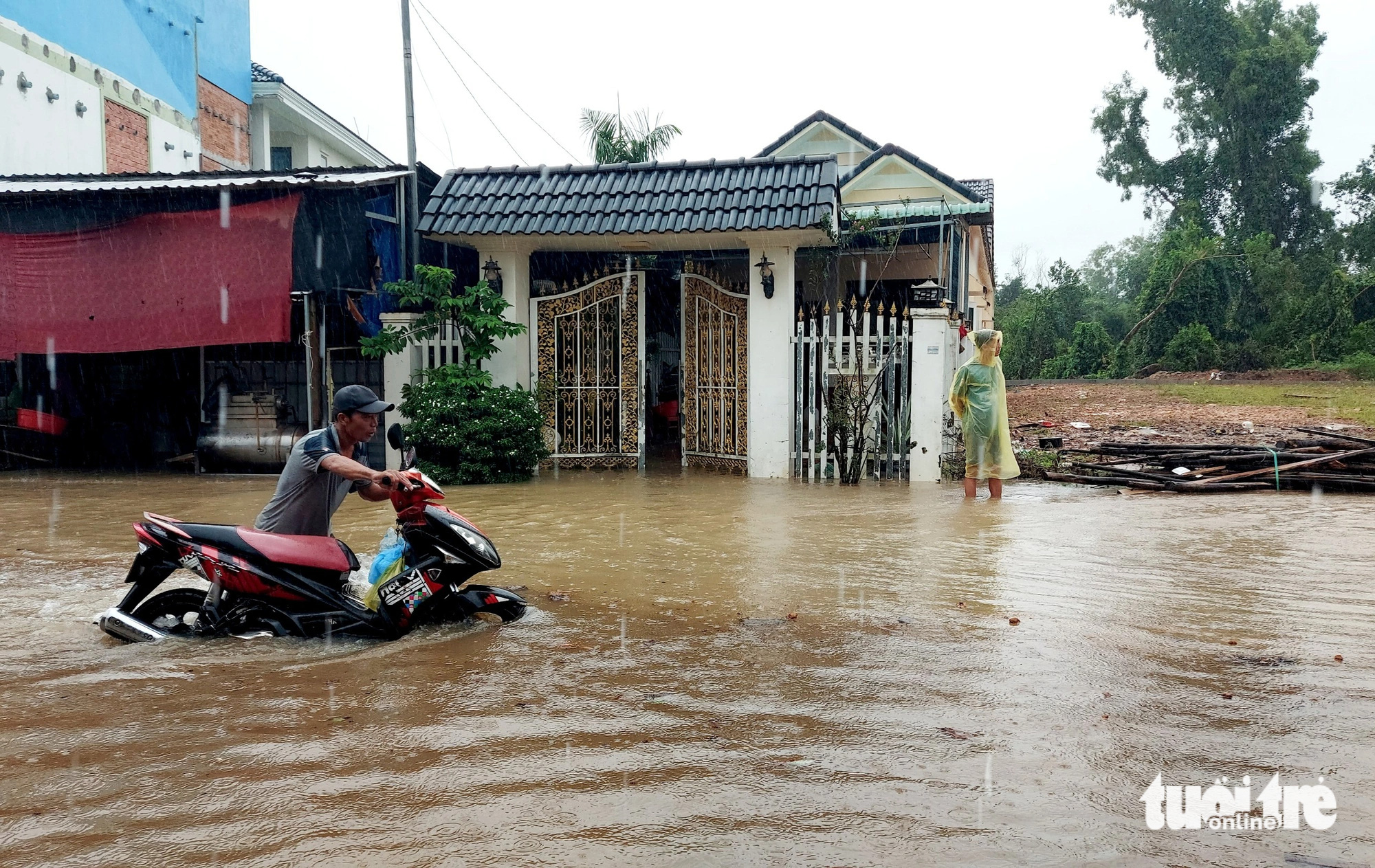 Nước ngập sâu và cục bộ, người dân bì bõm dắt xe vì chết máy - Ảnh: CHÍ CÔNG